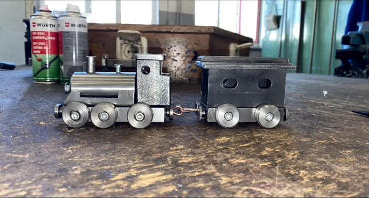Modell-Lokomotive mit Waggon aus Stahl auf der Werkbank
